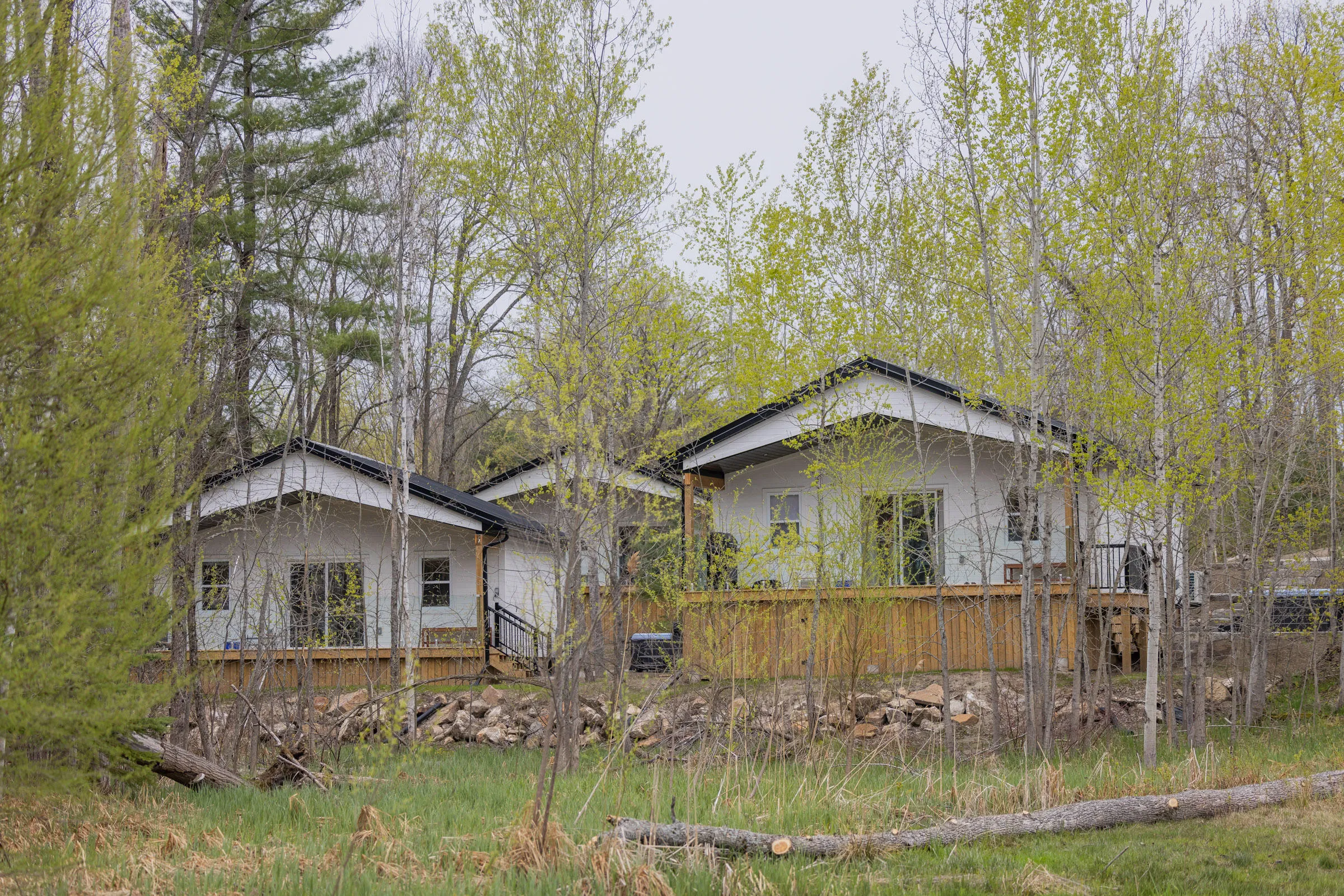 Inspire cabins with timber decks among trees.