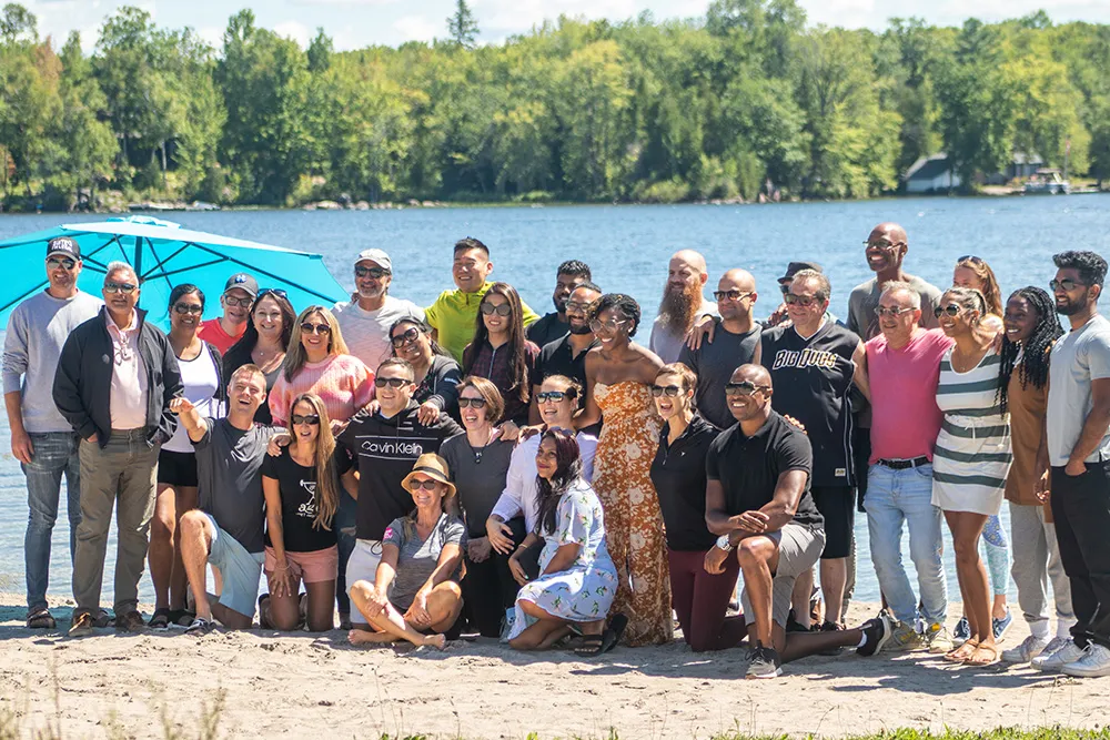 A group gathered on the beach beside the lake at Inspire.