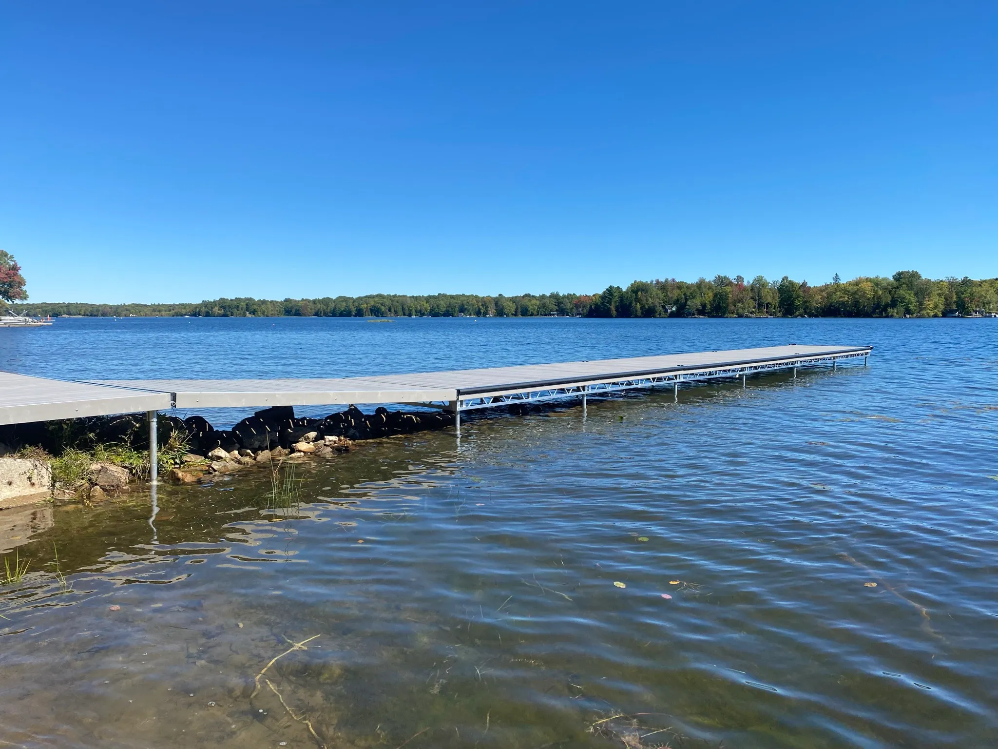 The shared dock extending across blue lake water.